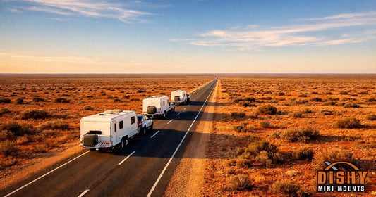 Convoy of caravans towed by 4WDs along outback highway through red desert